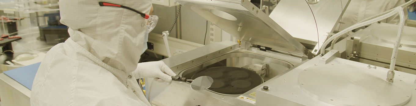 Lumentum employee in clean suit with wafer